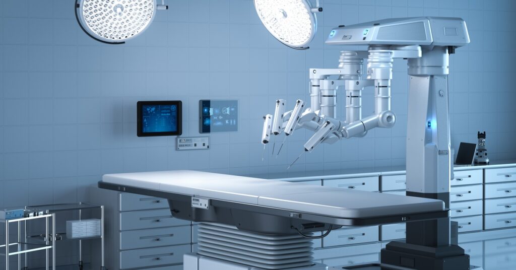 A surgical robot is by an empty surgical table under surgery lights. The robot's arms point to one area on the table.